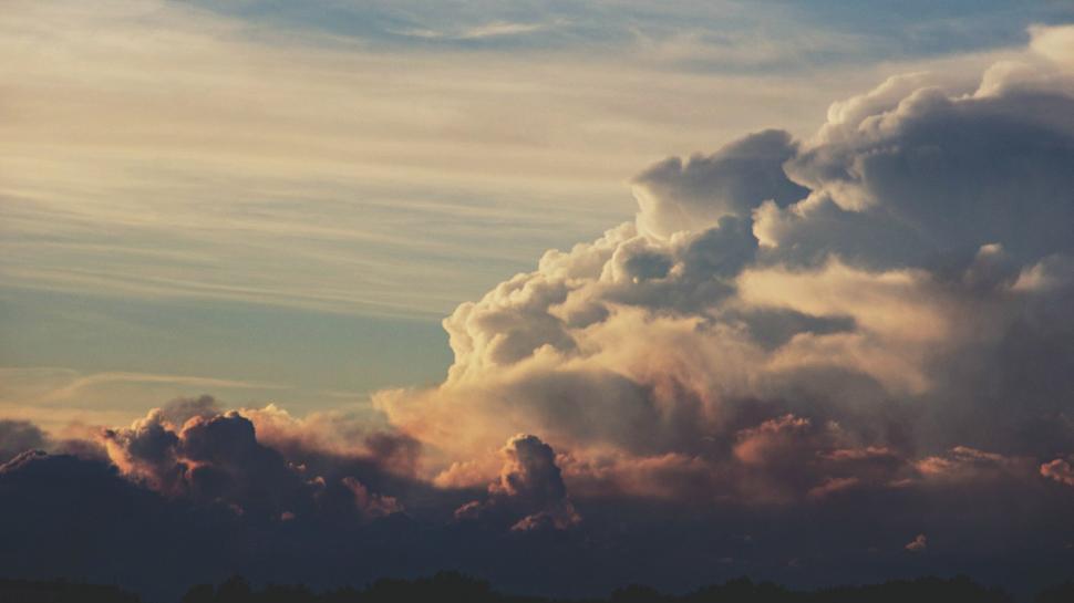 Free Image of A Plane Flying Through Cloudy Skies 