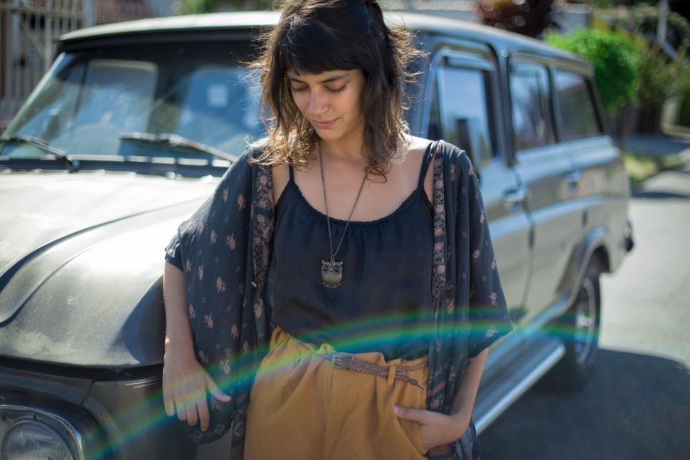 Free Image of Woman Standing in Front of Parked Car 