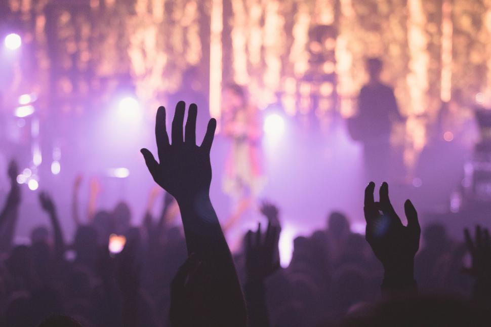 Free Image of Crowd of People Raising Hands in Front of Stage 