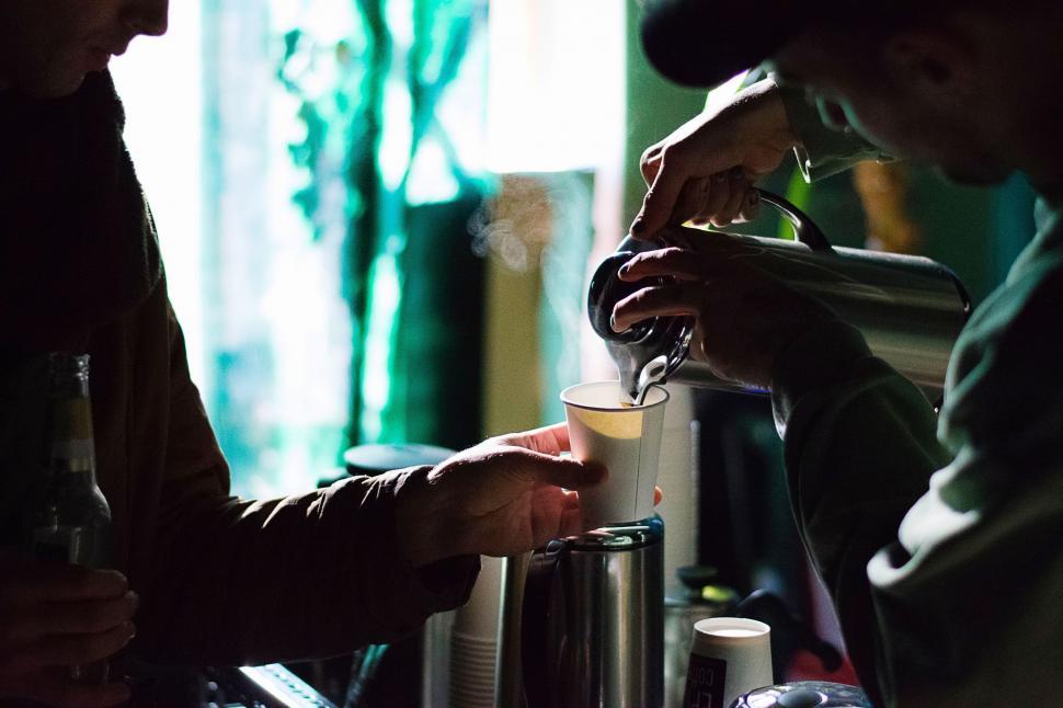 Free Image of Man Pouring Drink Into Cup at Bar 