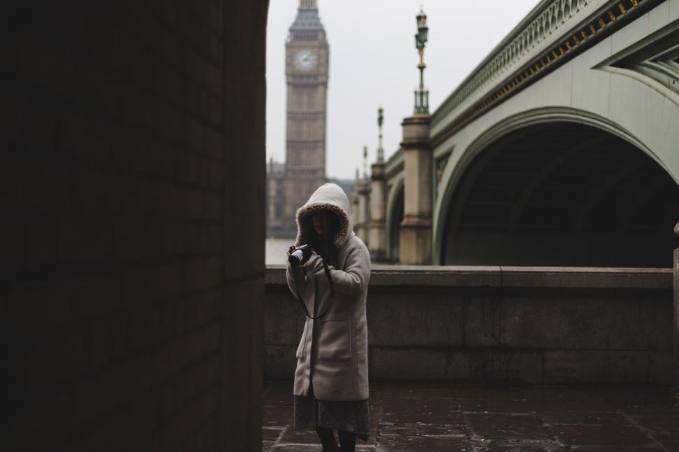 Free Image of Person Standing on Bridge Looking at Cell Phone 
