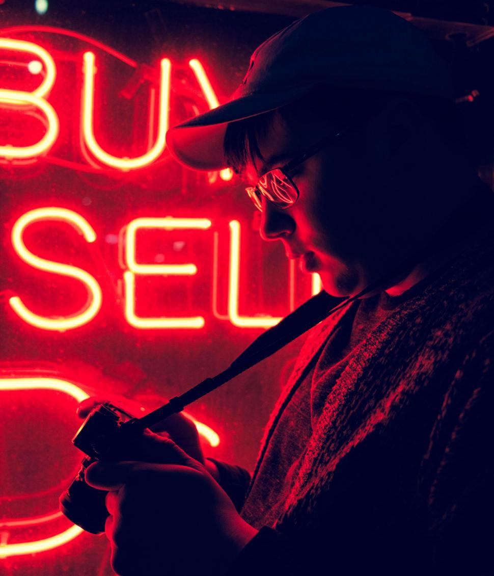 Free Image of Woman Standing in Front of Neon Sign 