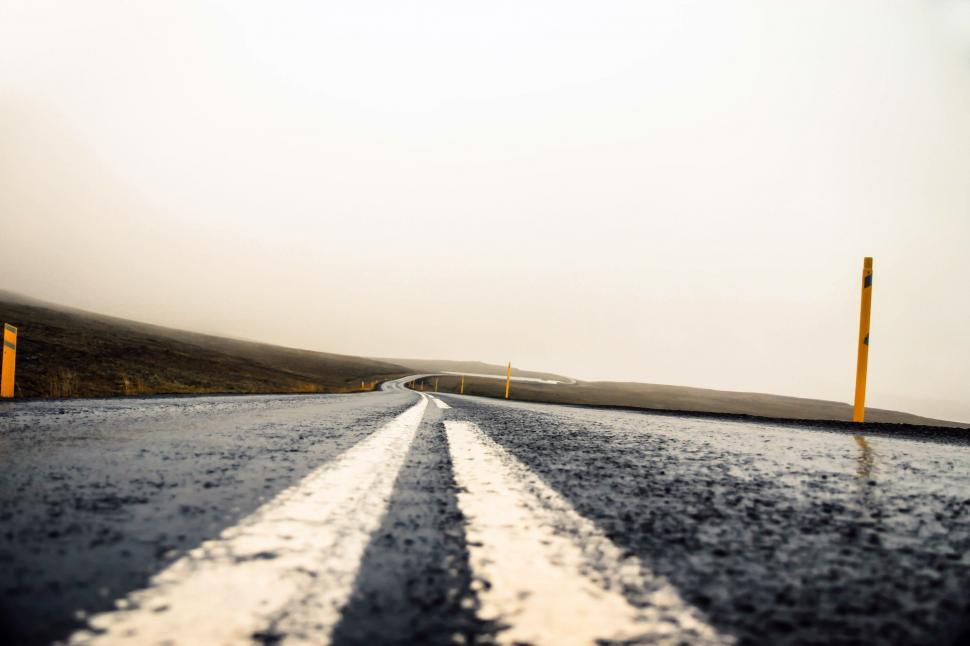 Free Image of Wet Road With Two Yellow Poles 