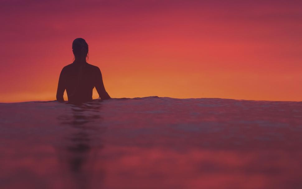 Free Image of Person Sitting on Surfboard in Water 