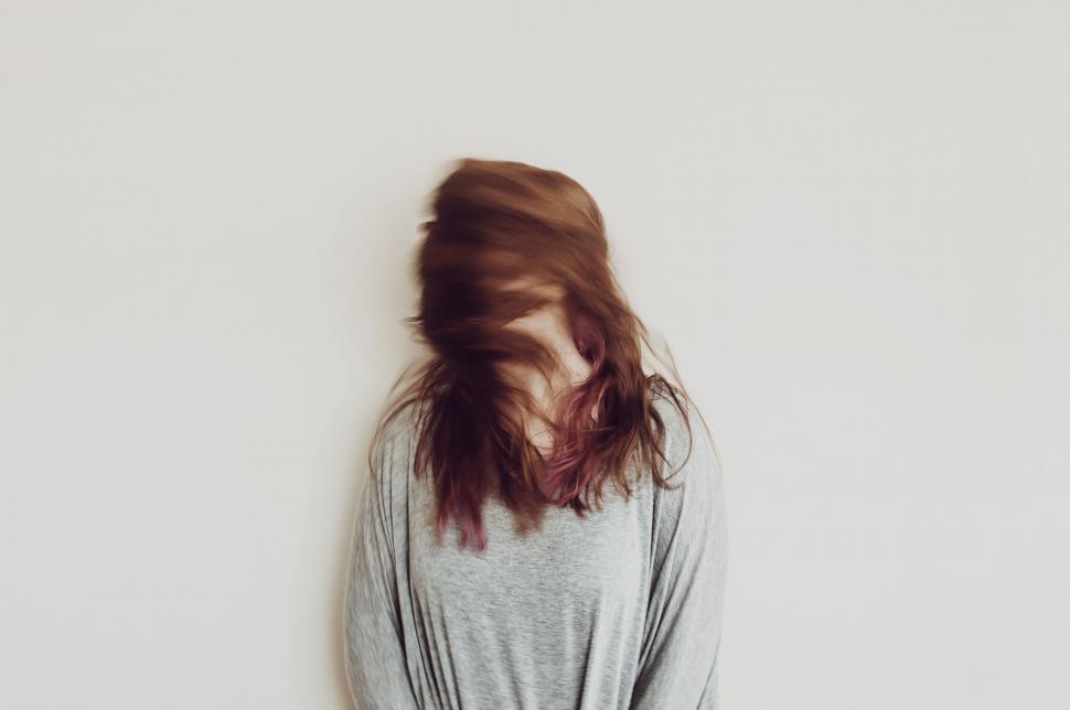 Free Image of Woman Standing in Front of White Wall 