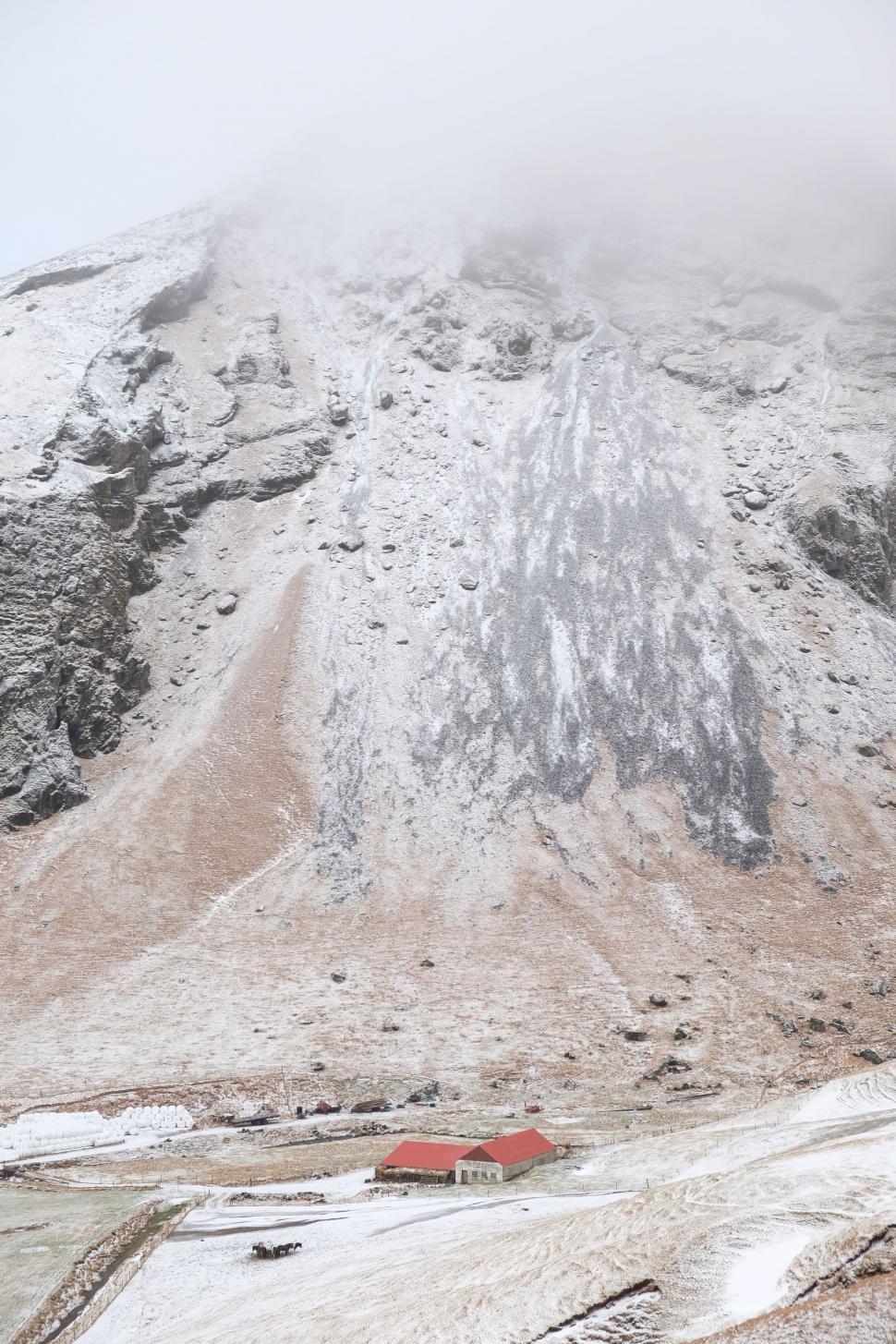 Free Image of Snow-Covered Mountain With Red Building 