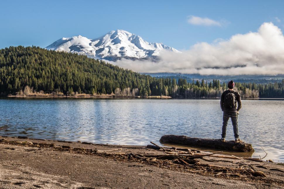 Free Image of Man Standing on Log by Lake 