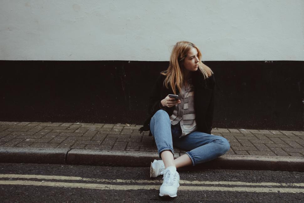 Free Image of Woman Sitting on Side of Road 