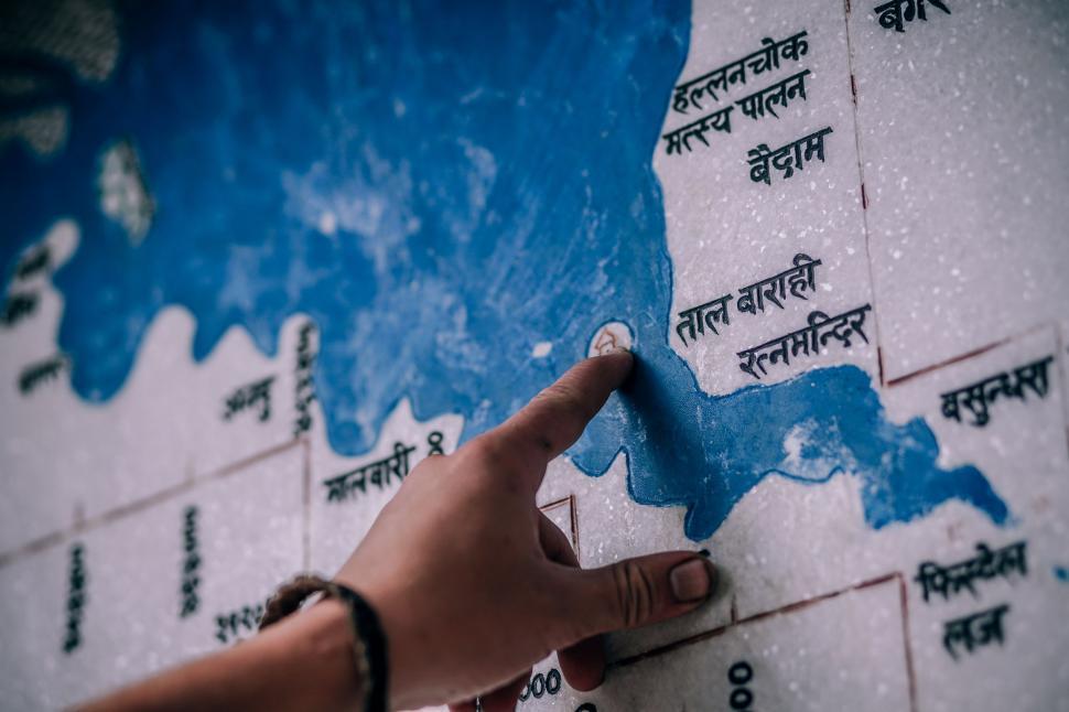 Free Image of Hand Pointing at Map on Wall 