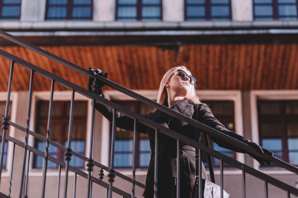 Free Image of Woman Standing on Staircase Looking Up at Sky 