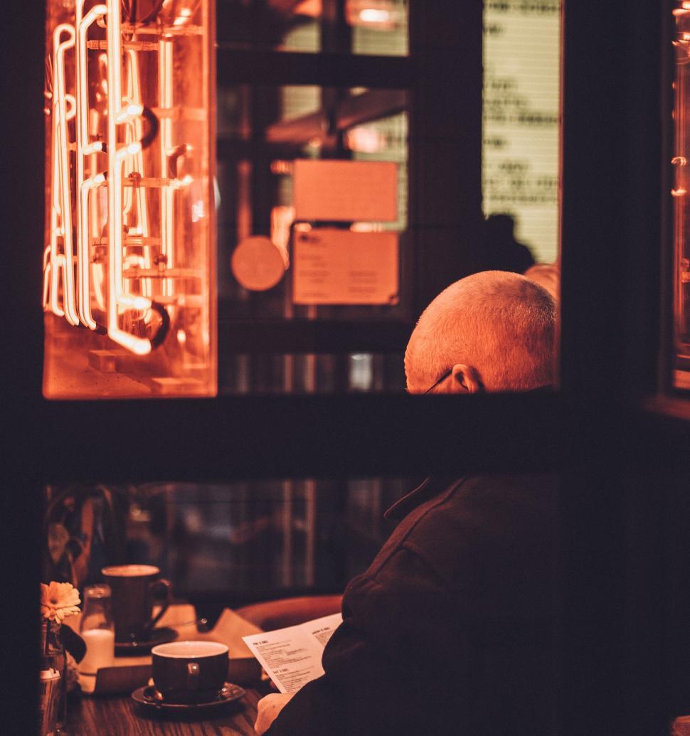 Free Image of Man Sitting at Table in Front of Window 