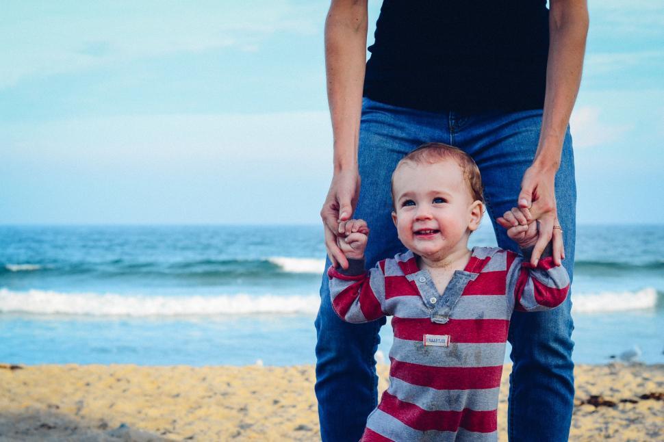 Free Image of Woman Holding the Hands of a Child on the Beach 