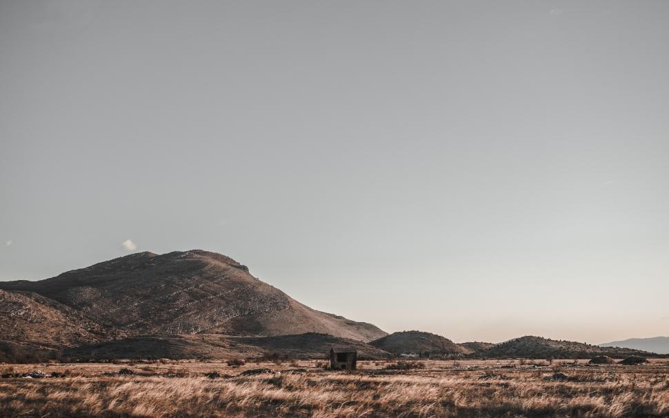Free Image of Grassy Plain With Mountains in the Background 