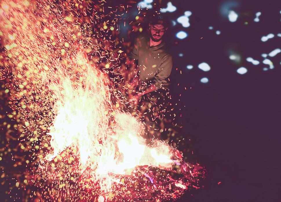 Free Image of Man Standing Next to Fire in the Dark 