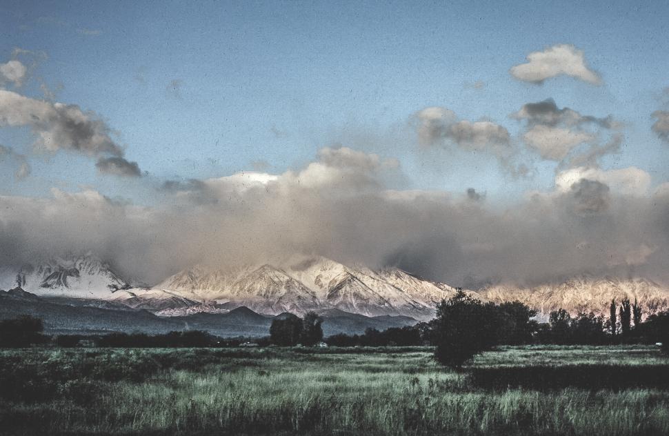 Free Image of Grainy film of Clouds over a snow mountain 