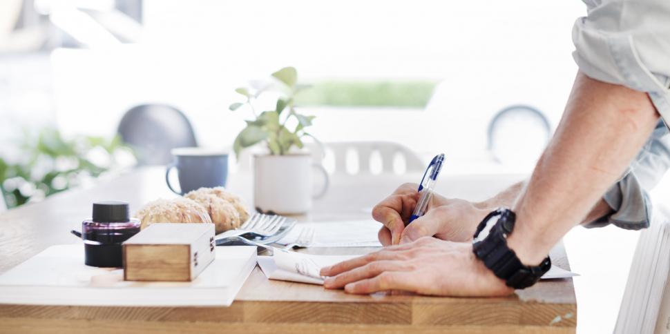 Free Image of Person Writing on Paper on Table 