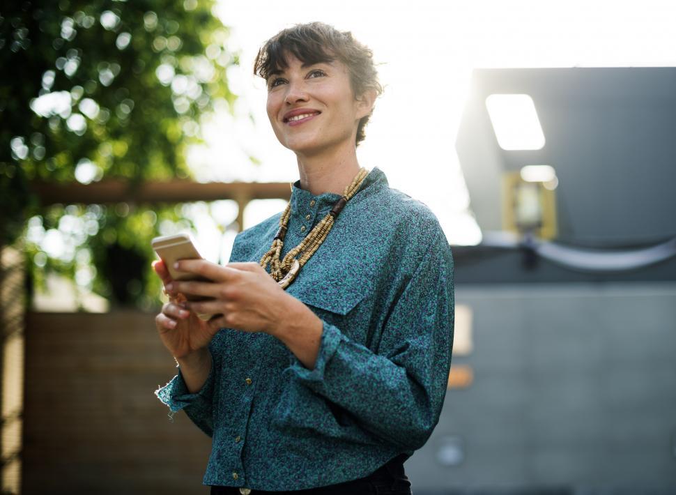 Free Image of Woman in Blue Shirt Holding Cell Phone 
