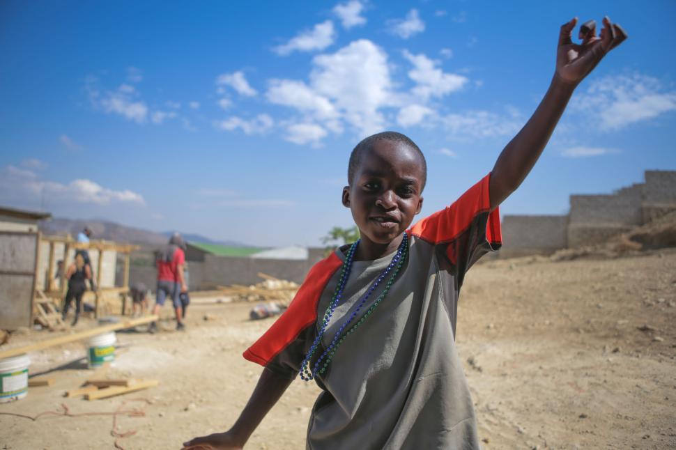 Free Image of Boy in Red and Gray Shirt Waving 