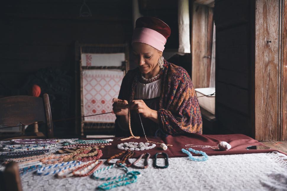 Free Image of Woman Sitting at Table With Necklaces 