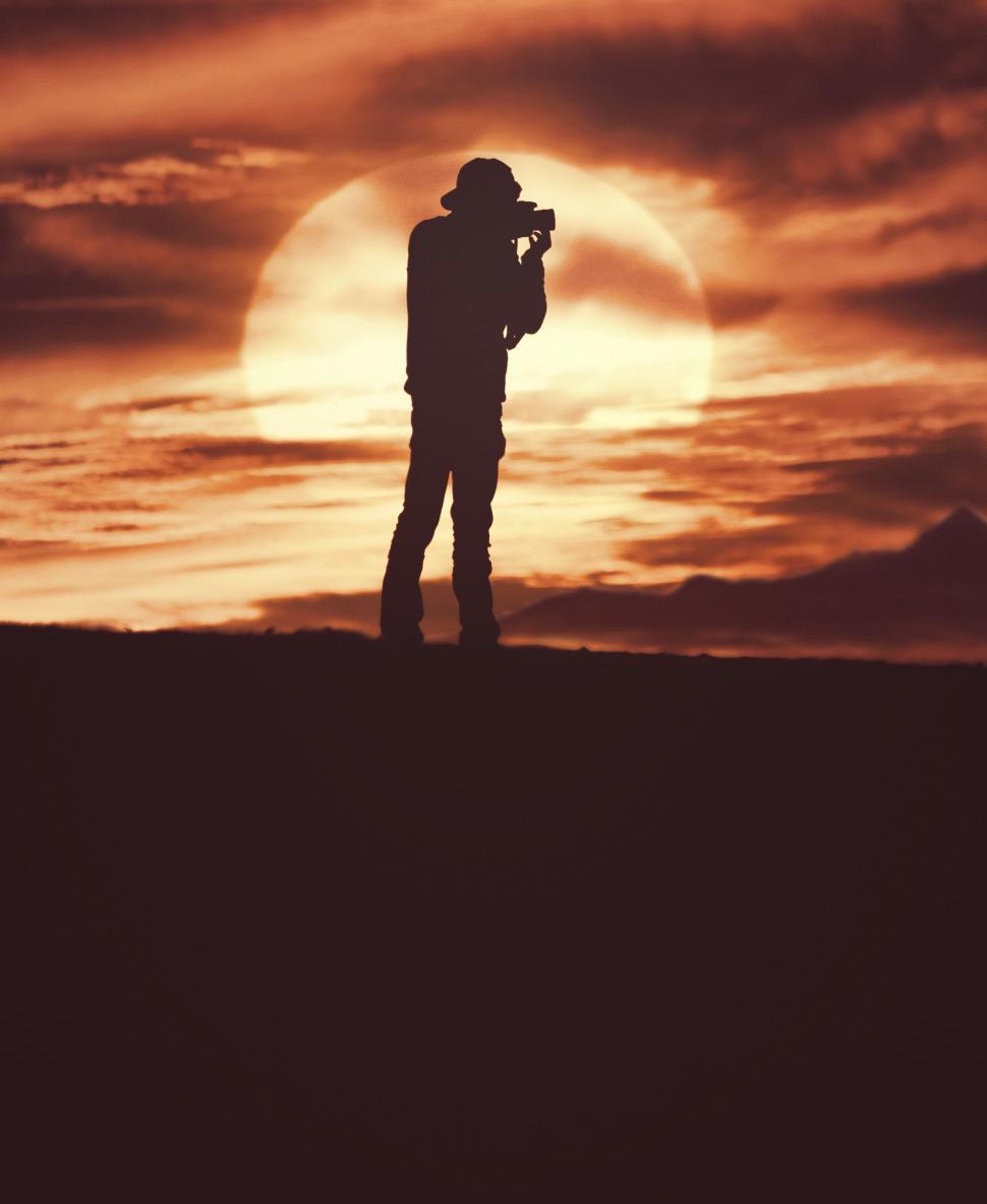 Free Image of Man Standing on Hill With Camera 