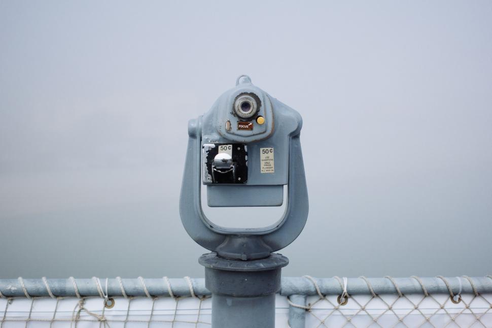 Free Image of Parking Meter Perched on Metal Fence 