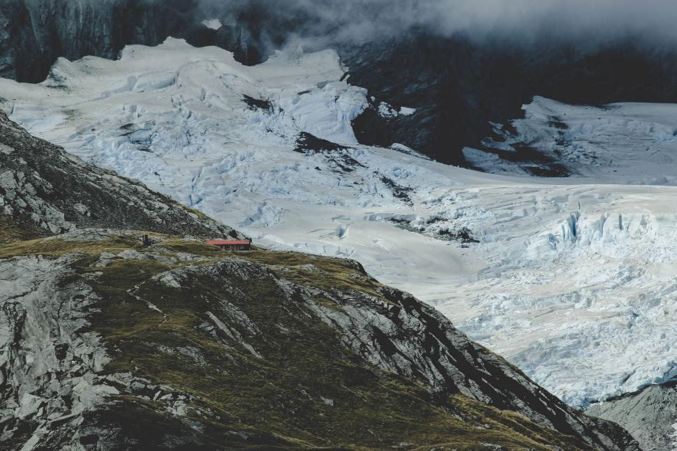 Free Image of Snow-Covered Mountain With Clouds in Distance 