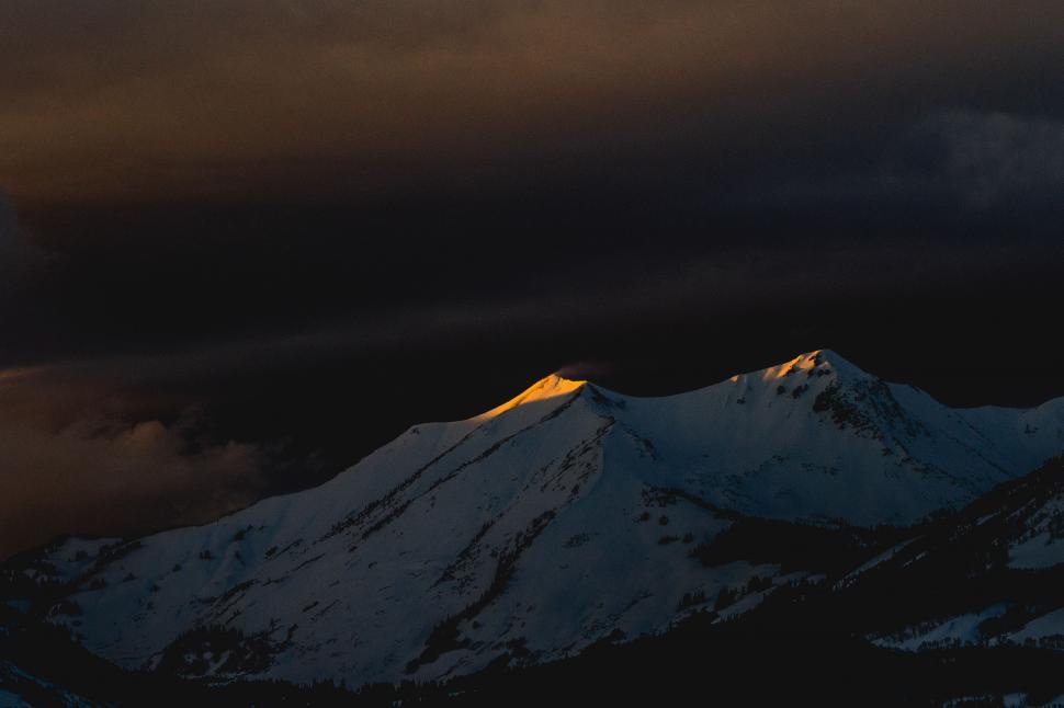 Free Image of Snow Covered Mountain Under Cloudy Sky 