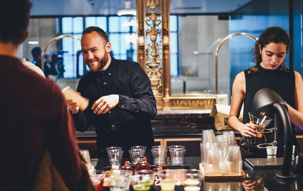 Free Image of Group of People Standing Around a Bar 