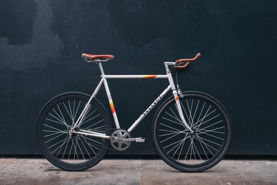 Free Image of Bike Parked Against Black Wall 