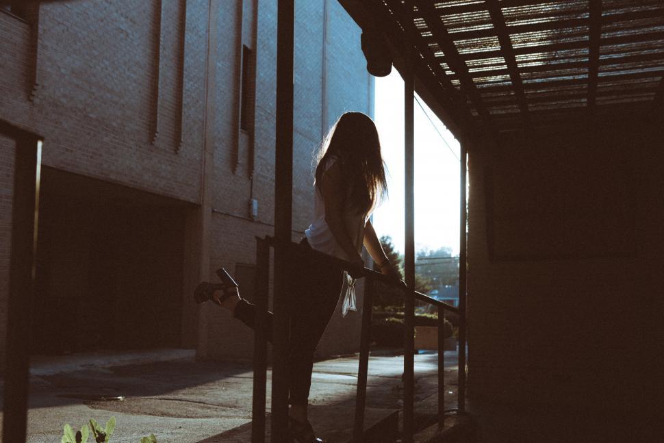 Free Image of Woman Standing on Porch Next to Fire Hydrant 