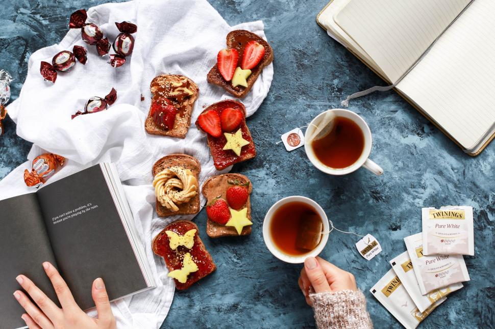 Free Image of Person Reading Book Next to Food 