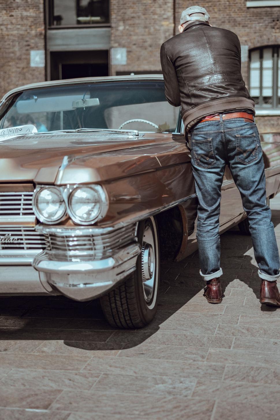 Free Image of Man Standing Next to Parked Car 