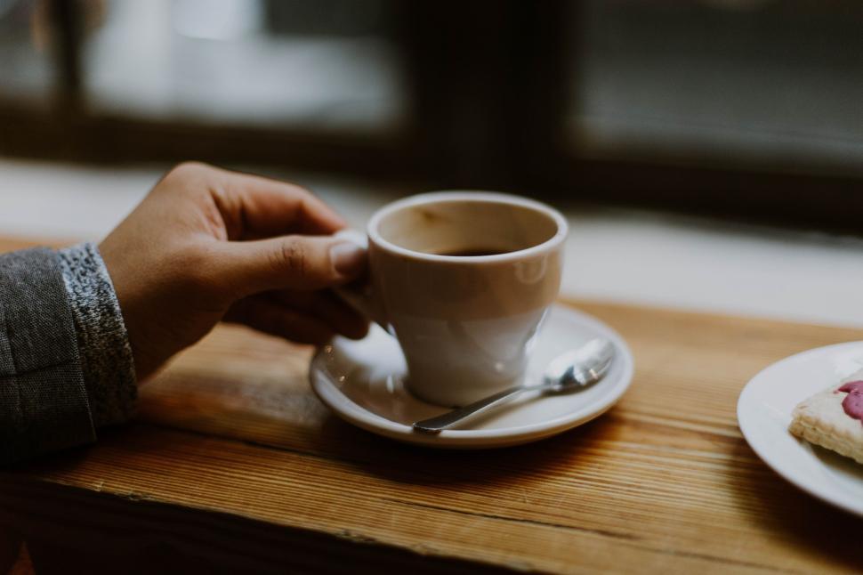 Free Image of Person Holding Cup of Coffee and Plate of Cookies 