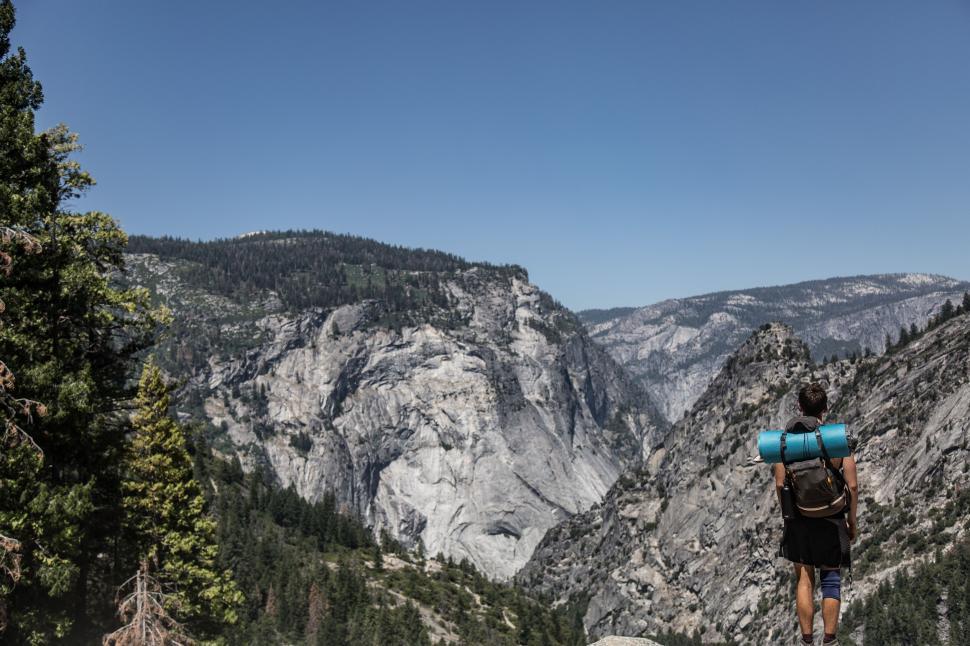 Free Image of Man Standing on Rock With Backpack 