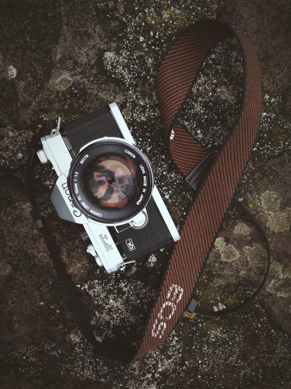 Free Image of Camera With Brown Strap on Rock 