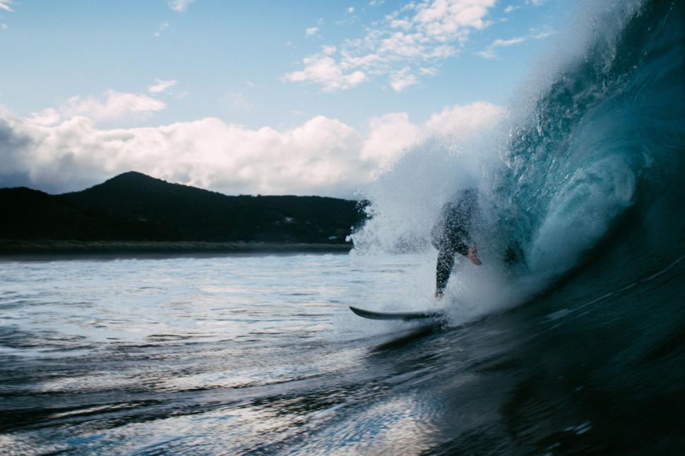Free Image of Man Riding Wave on Surfboard 