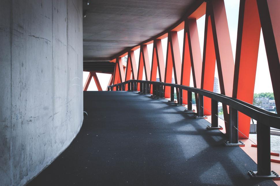 Free Image of Long Walkway With Red Railings Next to Building 