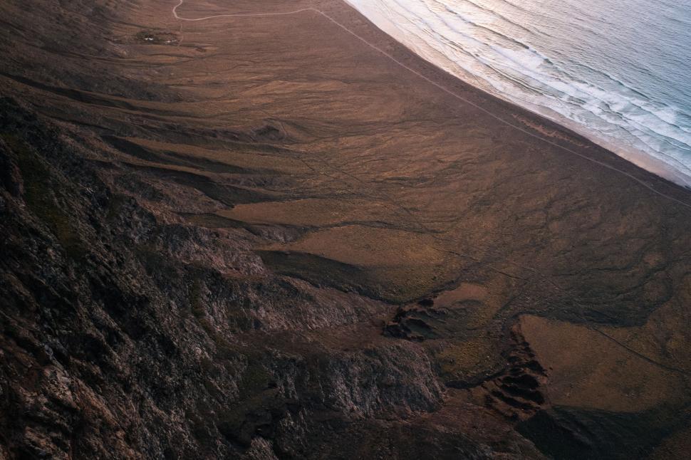 Free Image of Man Riding Surfboard on Sandy Beach 