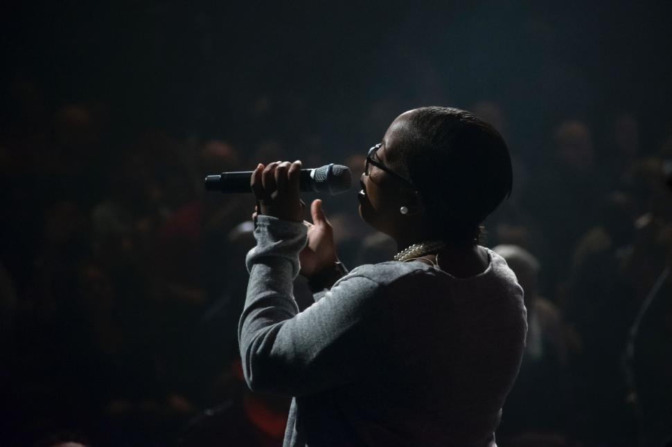 Free Image of Man Holding Microphone in Front of Crowd 