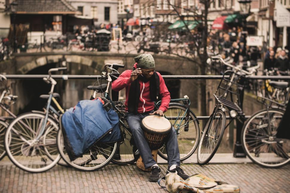 Free Image of Man Sitting on a Bench Next to Bikes 
