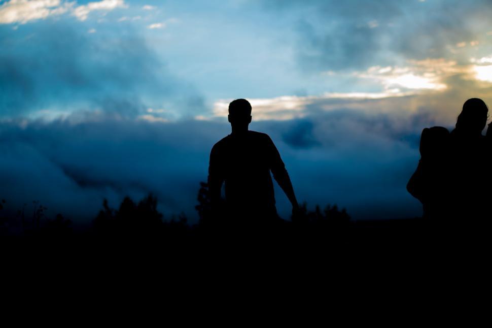 Free Image of Couple Standing Together Under Cloudy Sky 