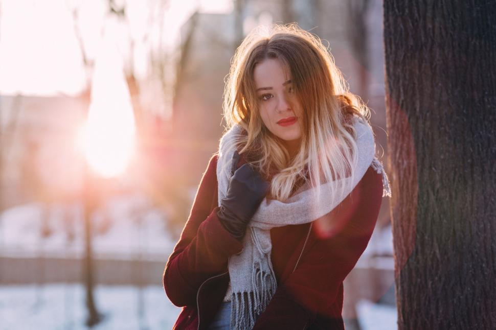 Free Image of Woman Standing by Snow-Covered Tree 