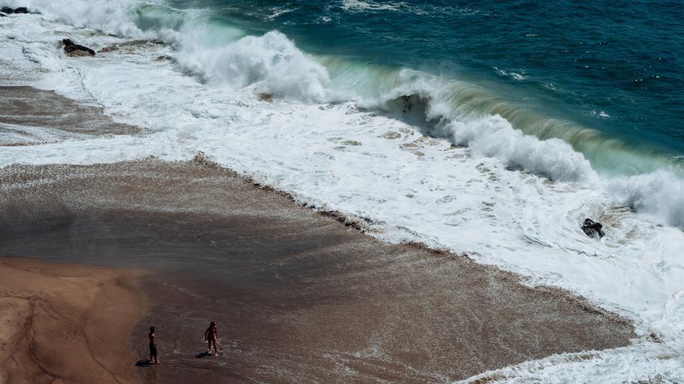 Free Image of Group of People Standing on Top of Beach by Ocean 