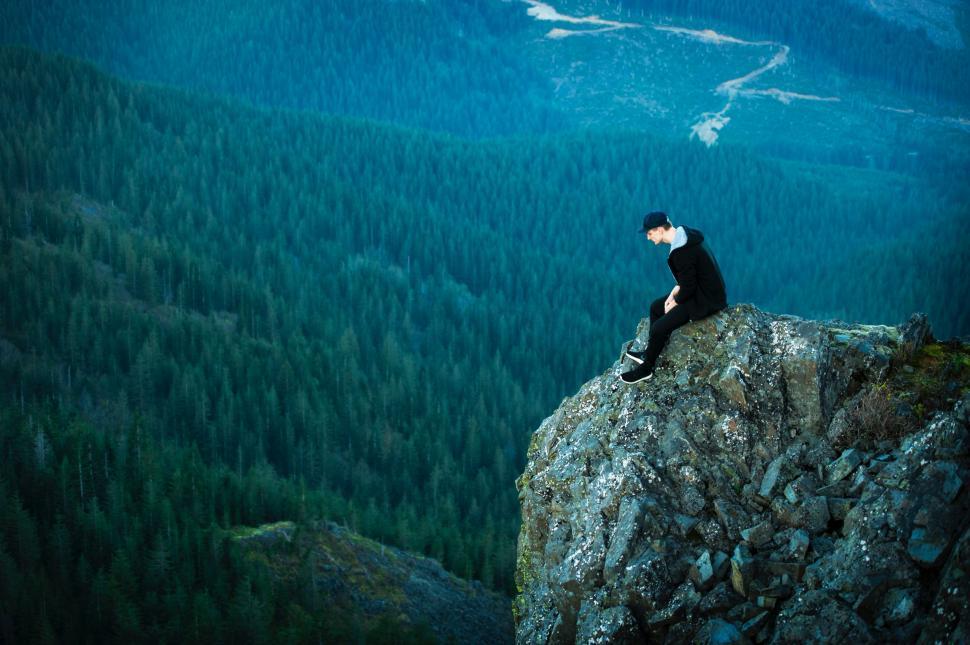 Free Image of Person Sitting on Top of a Cliff 