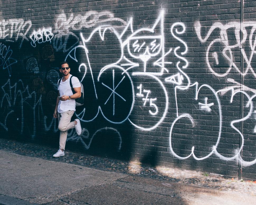 Free Image of Man Standing Next to Graffiti-covered Wall 