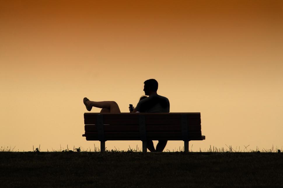 Free Image of Man Sitting on Top of Bench Next to Dog 