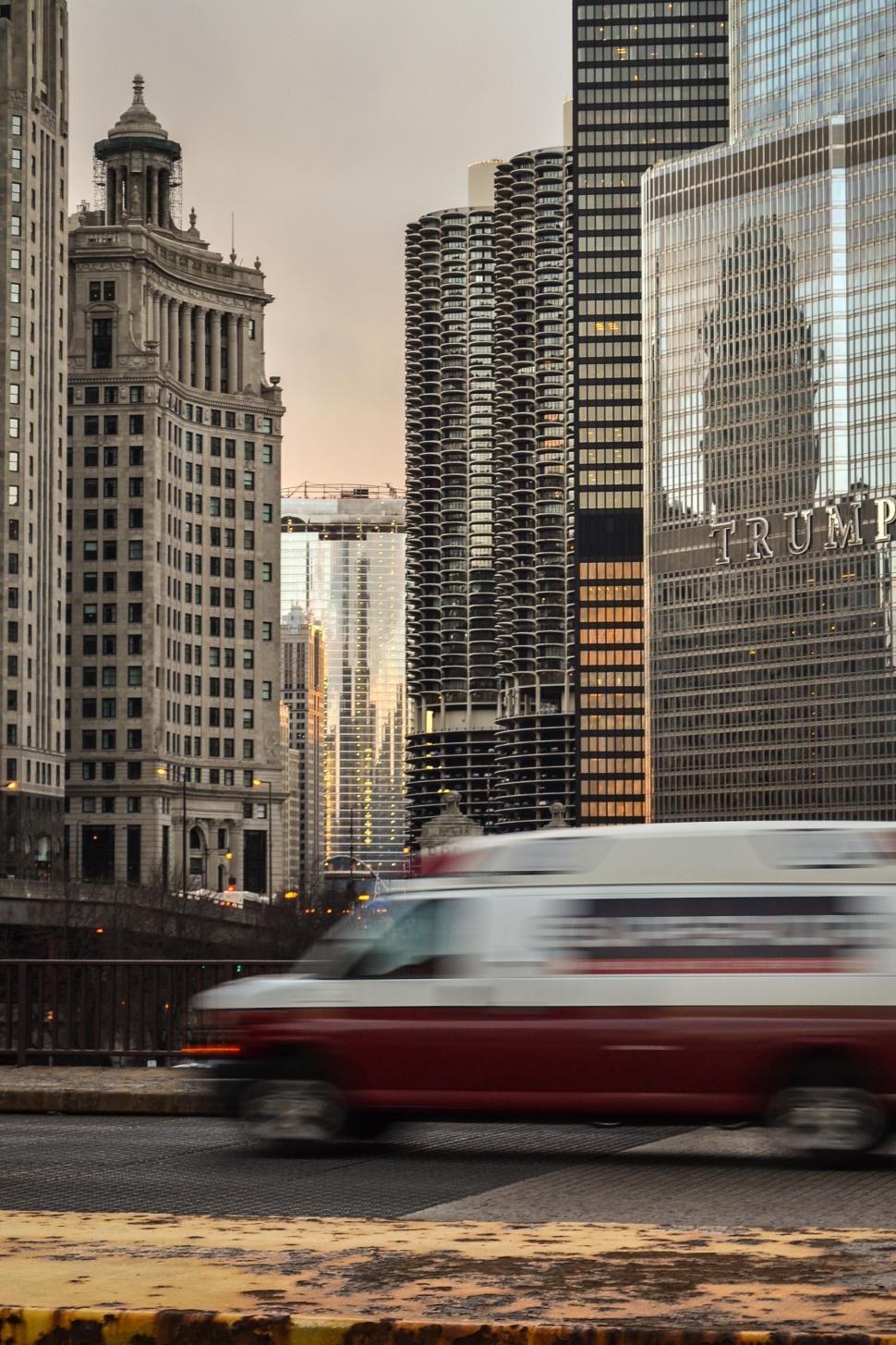Free Image of Red Car Driving Down Busy City Street 