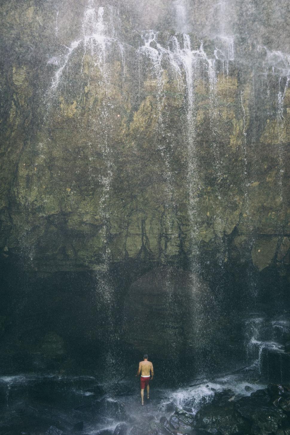 Free Image of Man Standing in Front of Waterfall 