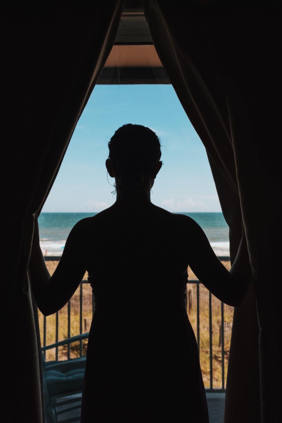 Free Image of Person Standing in Front of Window 