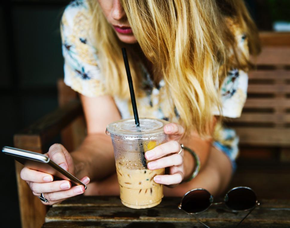 Free Image of Woman Sitting at Table Using Cell Phone 